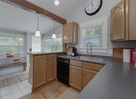 a kitchen with stainless steel appliances granite countertop a sink a stove and a wooden floors