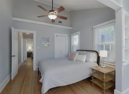 a bedroom with a bed chandelier and a window