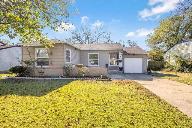 a front view of house with yard and trees around