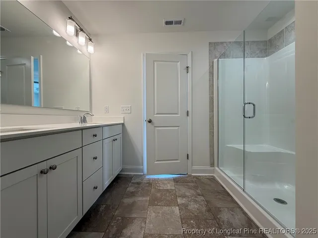 a bathroom with a shower sink and mirror