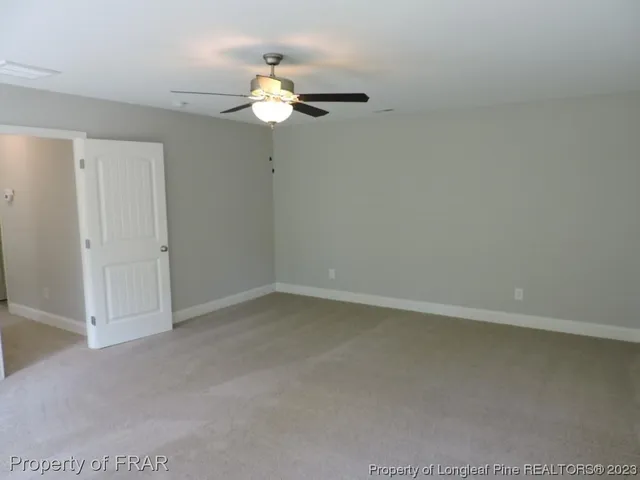 an empty room with a chandelier fan