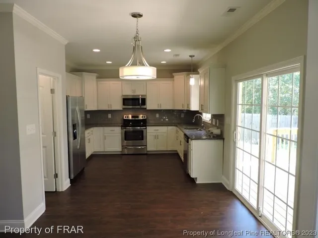 a kitchen with a sink appliances cabinets and a counter top space