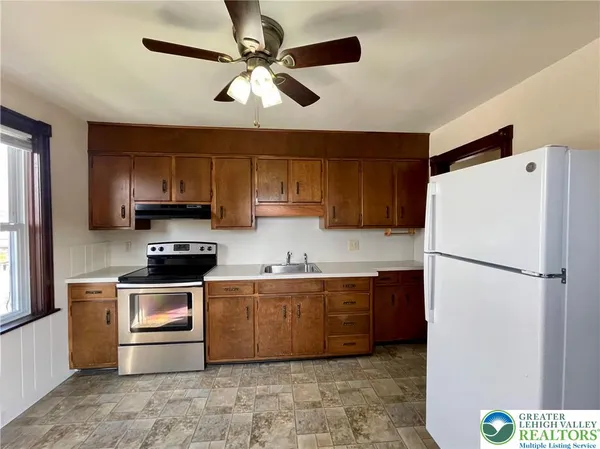 a kitchen with stainless steel appliances granite countertop a refrigerator sink and stove