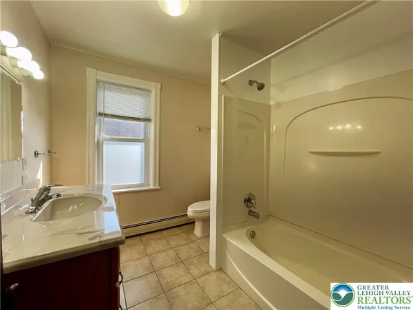 a bathroom with a granite countertop sink a toilet and shower