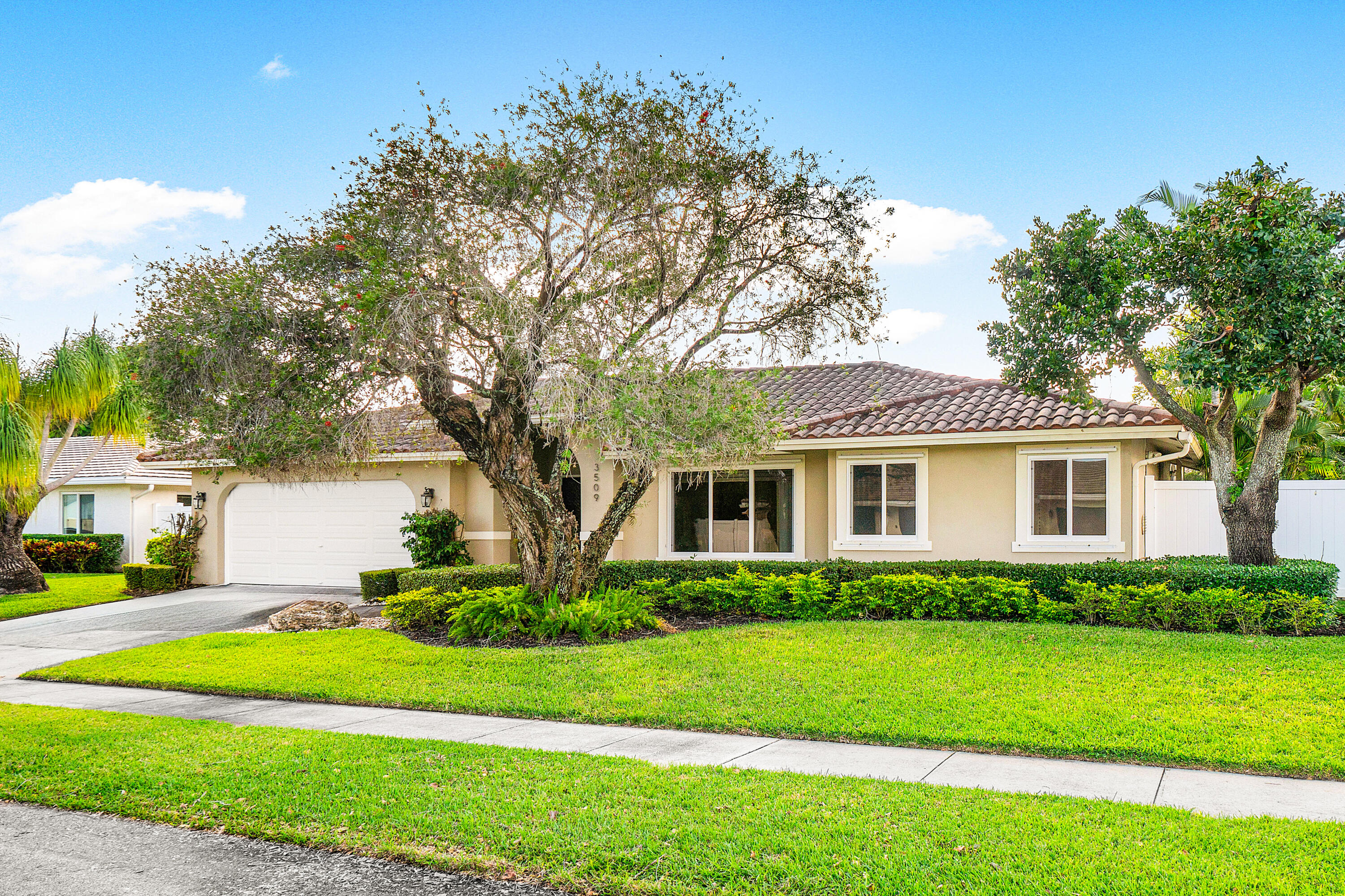 a front view of a house with a garden and yard