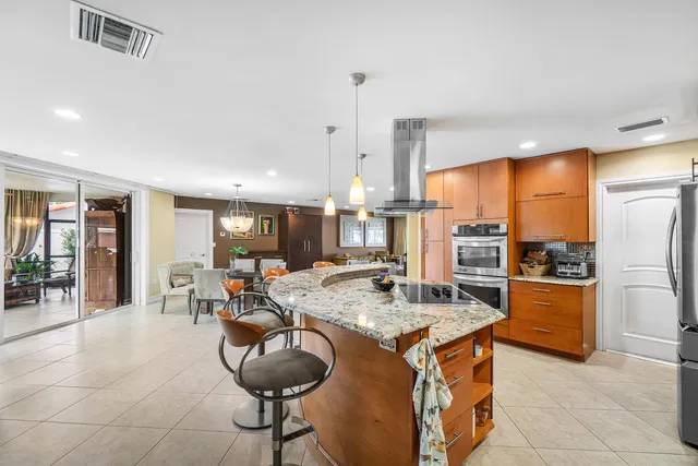a kitchen with stainless steel appliances granite countertop a stove refrigerator and cabinets
