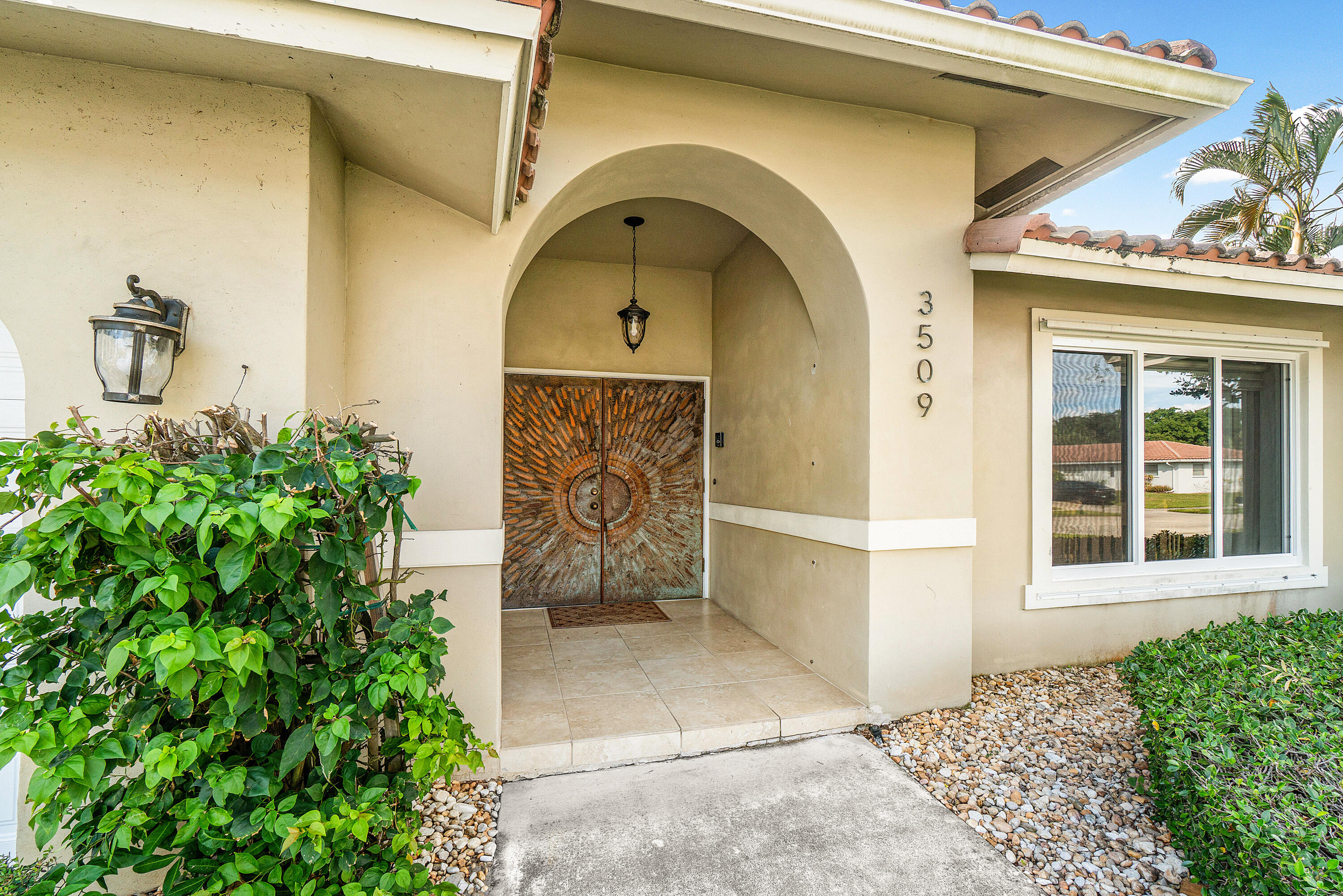 3509 Northwest 26th Court Boca Raton, FL 33434 - Photo 2 of 33 a front view of a house with a garden