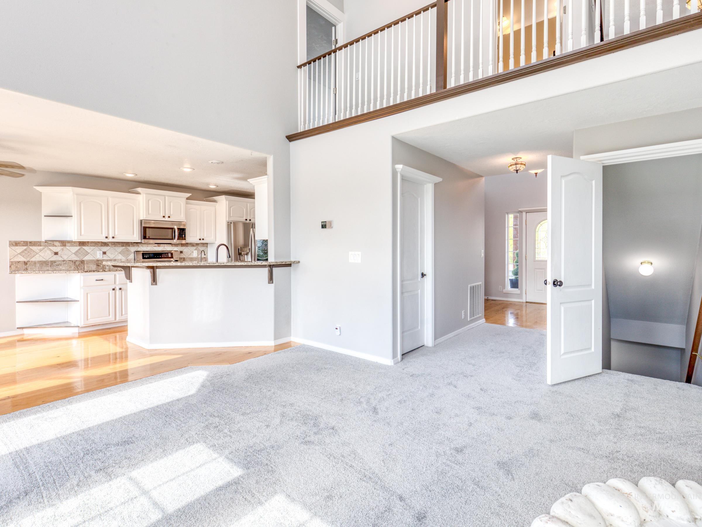 16277 Sand Hollow Road Caldwell, ID 83607 - Photo 14 of 39 Unfurnished living room with a towering ceiling, light colored carpet, light wood-style floors, and recessed lighting