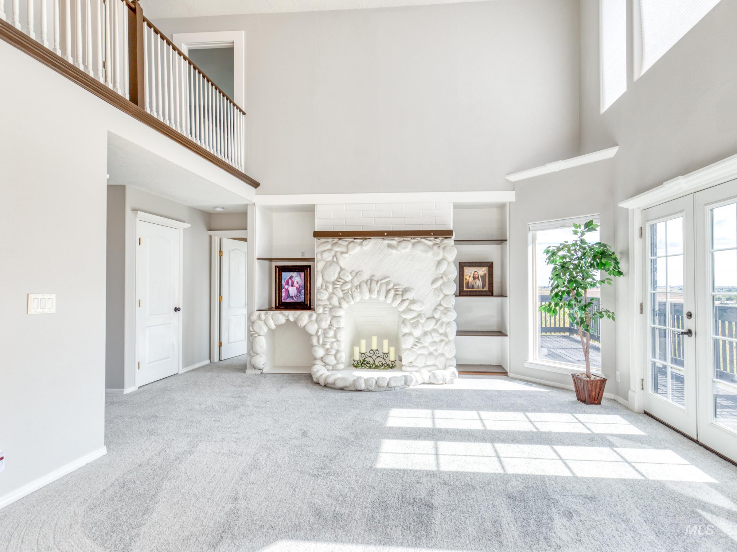 16277 Sand Hollow Road Caldwell, ID 83607 - Photo 15 of 39 Unfurnished living room with a high ceiling, carpet flooring, french doors, and a fireplace