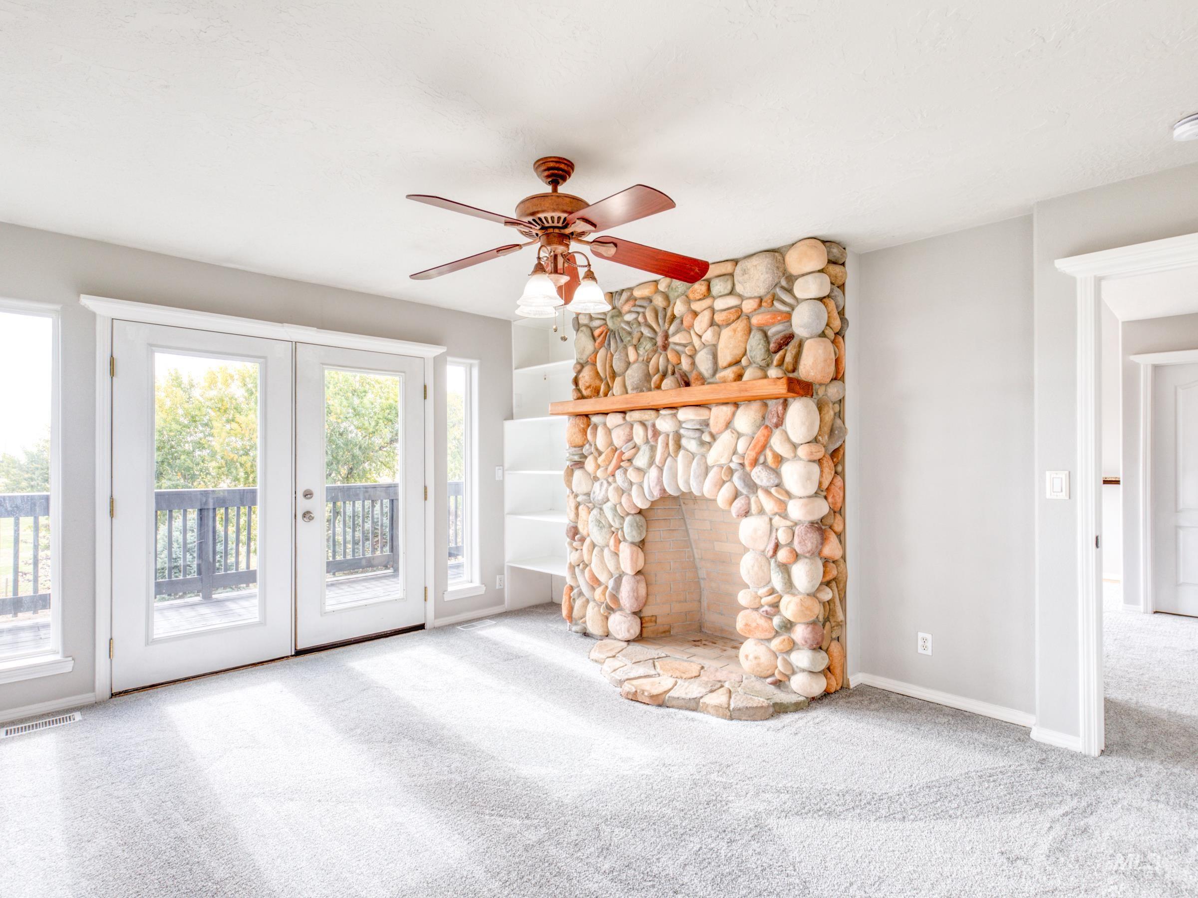 16277 Sand Hollow Road Caldwell, ID 83607 - Photo 18 of 39 Unfurnished master featuring light carpet, a fireplace, and a ceiling fan