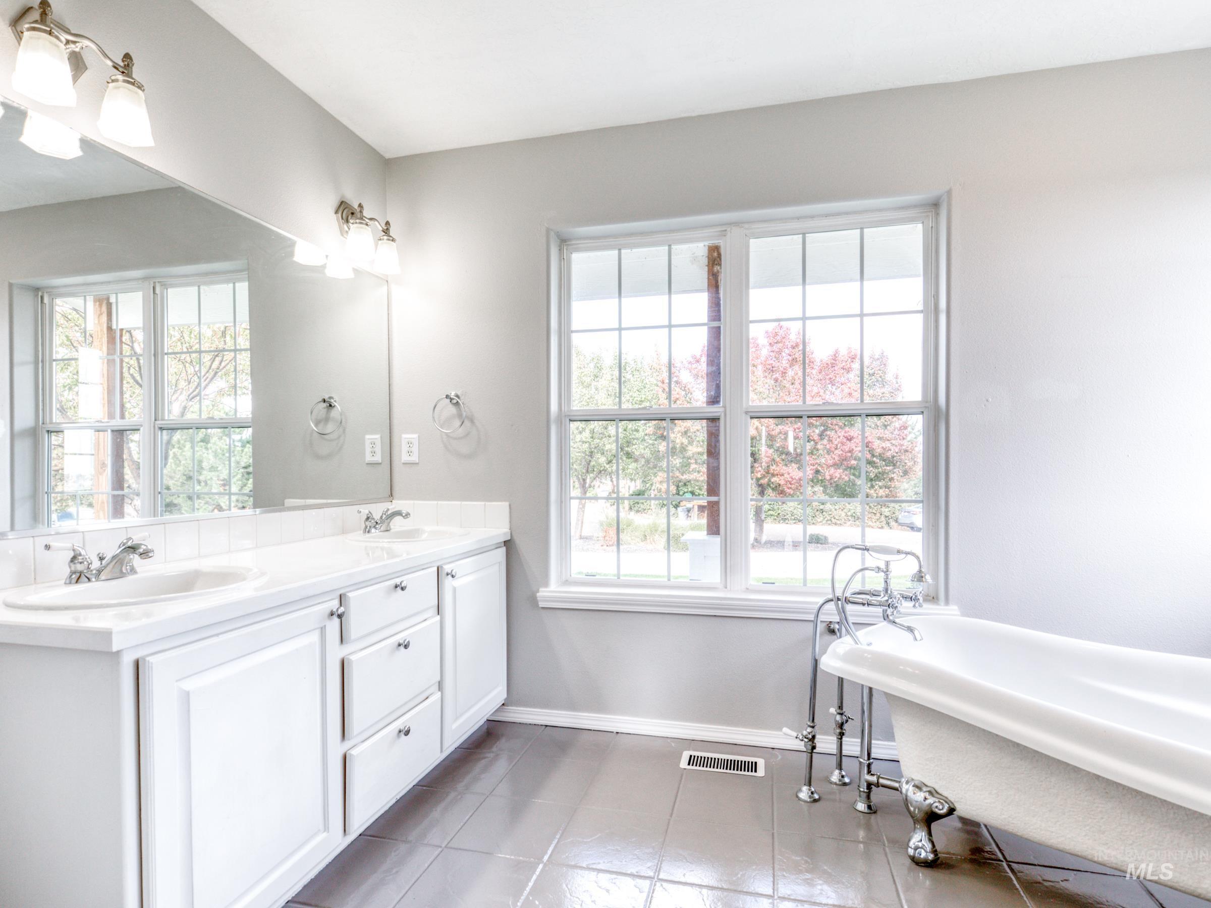 16277 Sand Hollow Road Caldwell, ID 83607 - Photo 20 of 39 Full bathroom featuring a soaking tub, double vanity, plenty of natural light, and light tile patterned floors