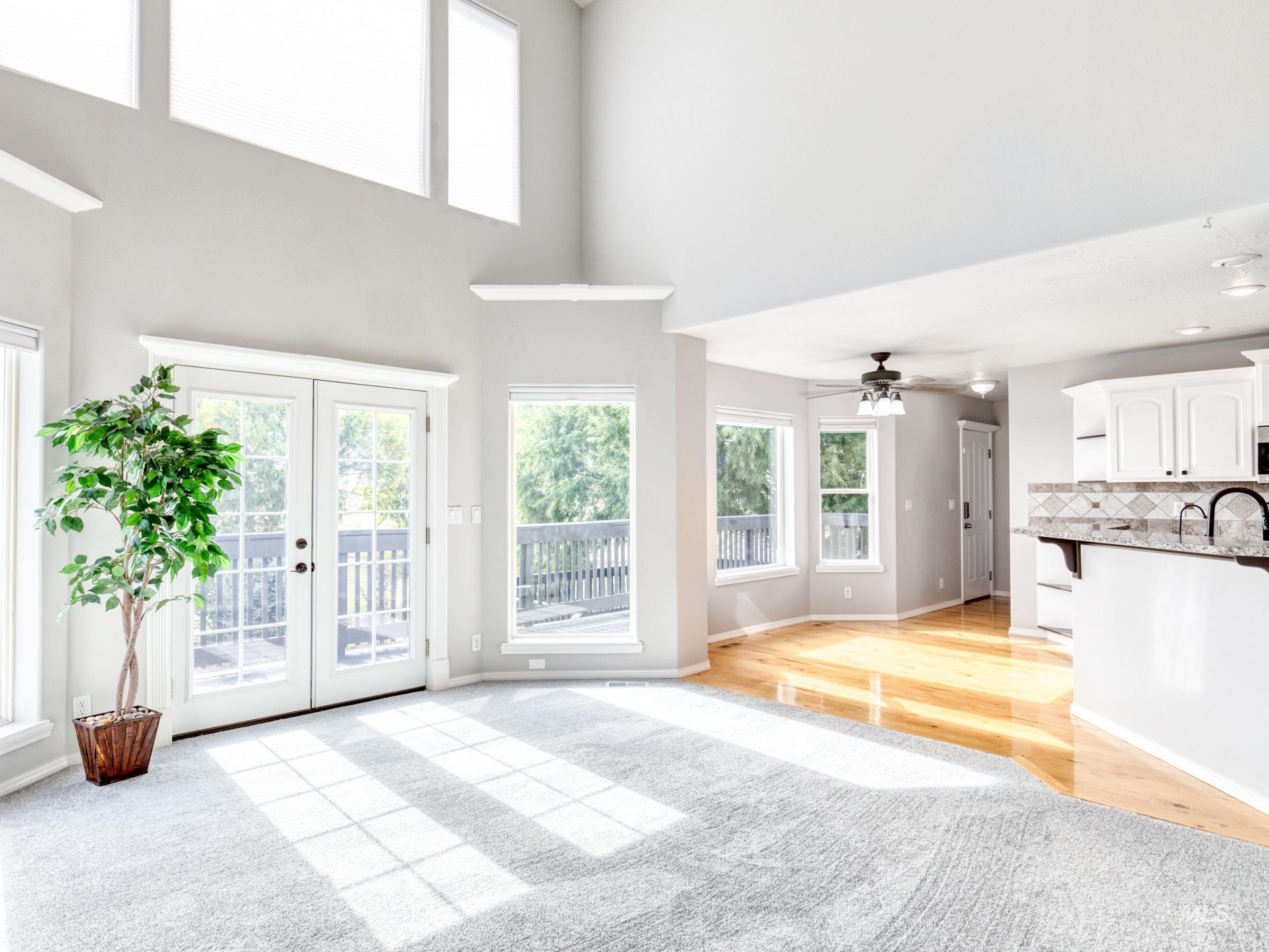 16277 Sand Hollow Road Caldwell, ID 83607 - Photo 22 of 39 Unfurnished living room featuring a high ceiling, french doors, a ceiling fan, light wood-type flooring, and light carpet