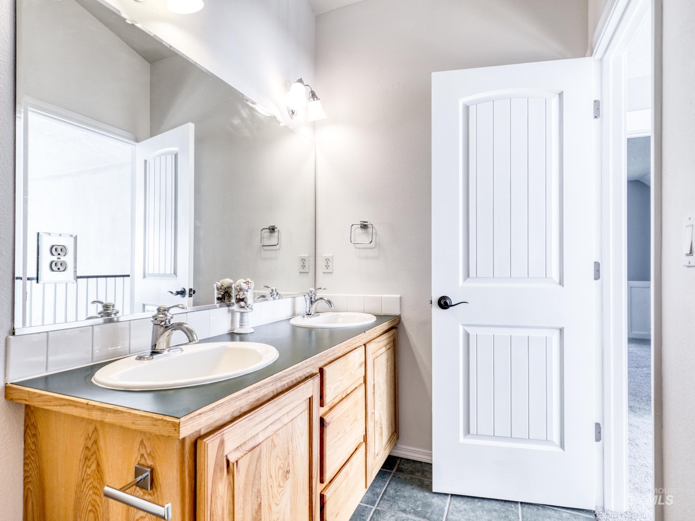 16277 Sand Hollow Road Caldwell, ID 83607 - Photo 25 of 39 Full bathroom with dark tile patterned flooring and double vanity