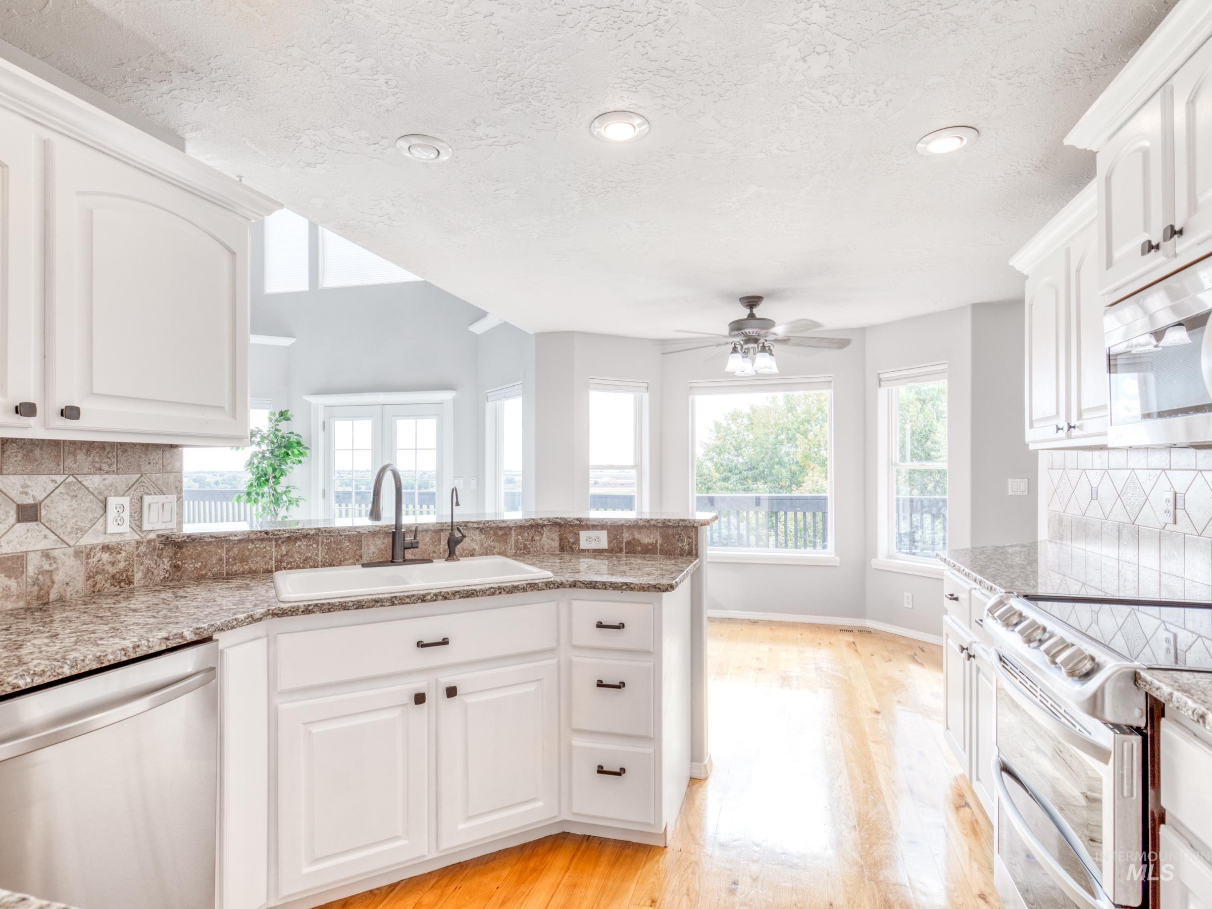 16277 Sand Hollow Road Caldwell, ID 83607 - Photo 29 of 39 Kitchen featuring tasteful backsplash, stainless steel appliances, white cabinetry, healthy amount of natural light, and recessed lighting