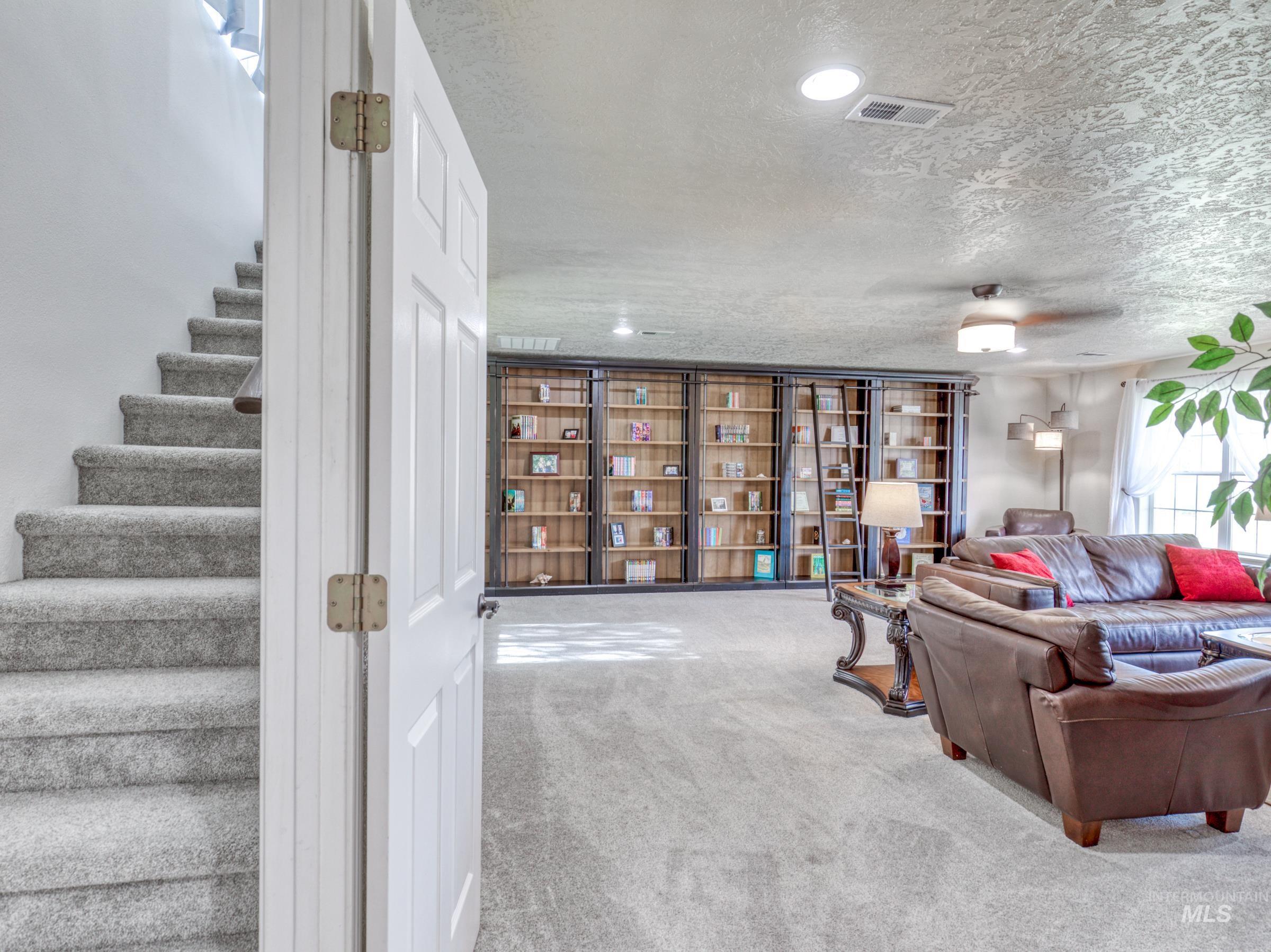 16277 Sand Hollow Road Caldwell, ID 83607 - Photo 30 of 39 Carpeted living area with stairs and a textured ceiling