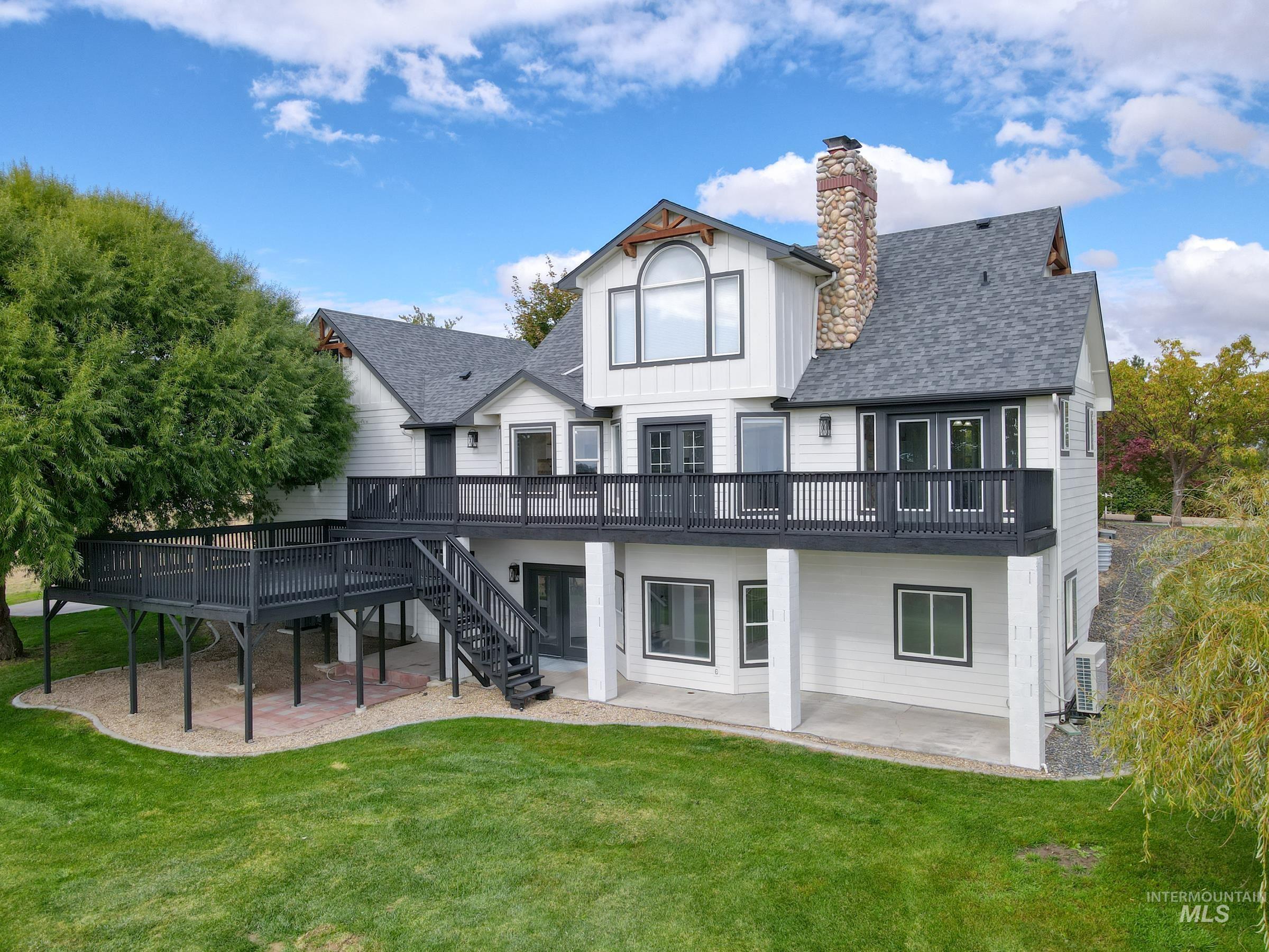 16277 Sand Hollow Road Caldwell, ID 83607 - Photo 34 of 39 Rear view of house with a patio area, a deck, a shingled roof, and a yard