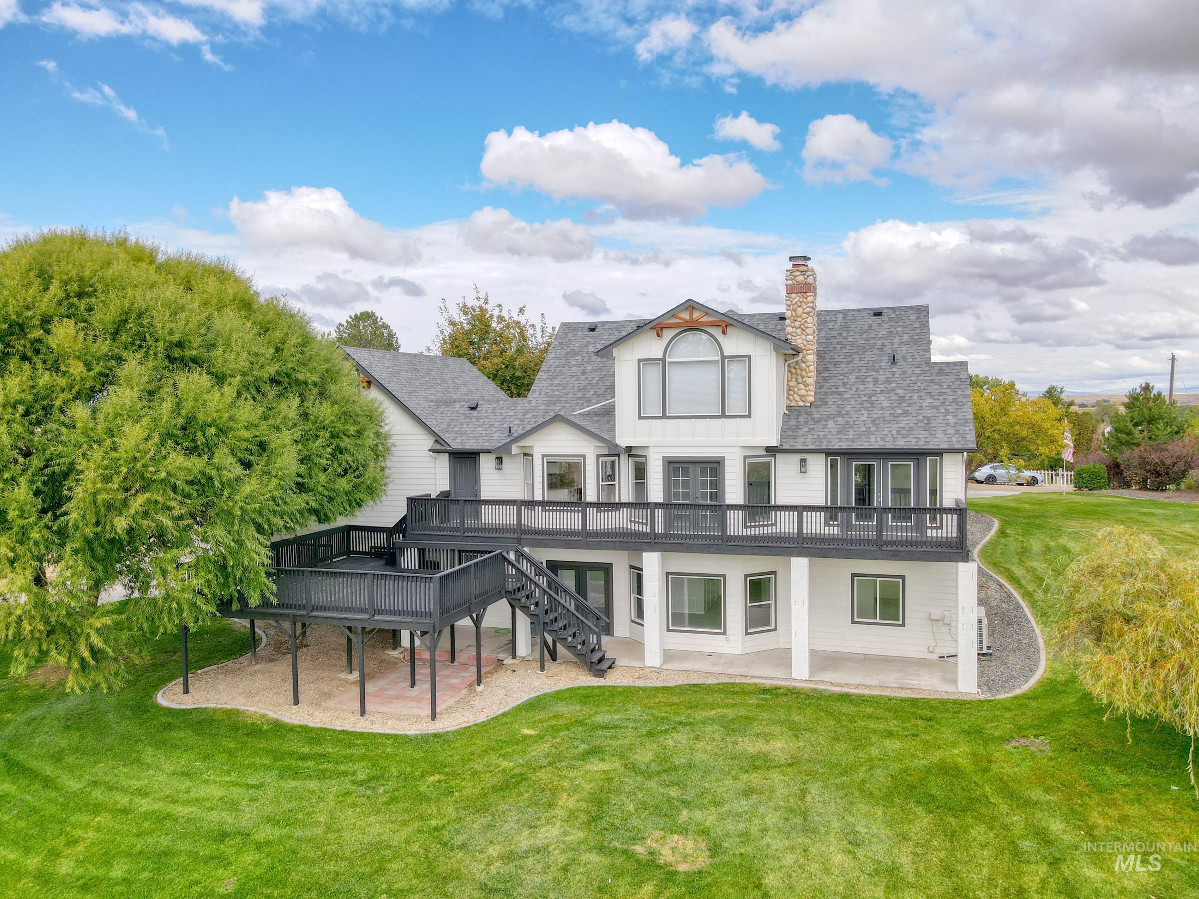 16277 Sand Hollow Road Caldwell, ID 83607 - Photo 37 of 39 Back of house featuring a patio, a wooden deck, a lawn, and stairway