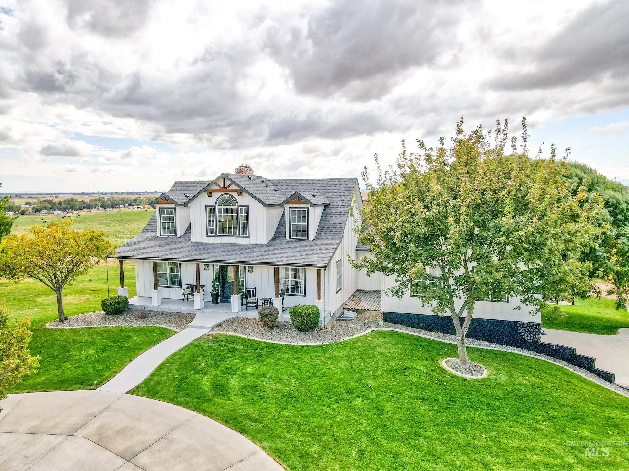 16277 Sand Hollow Road Caldwell, ID 83607 - Photo 5 of 39 View of front of property with covered porch, a front lawn, a shingled roof, a chimney, and board and batten siding