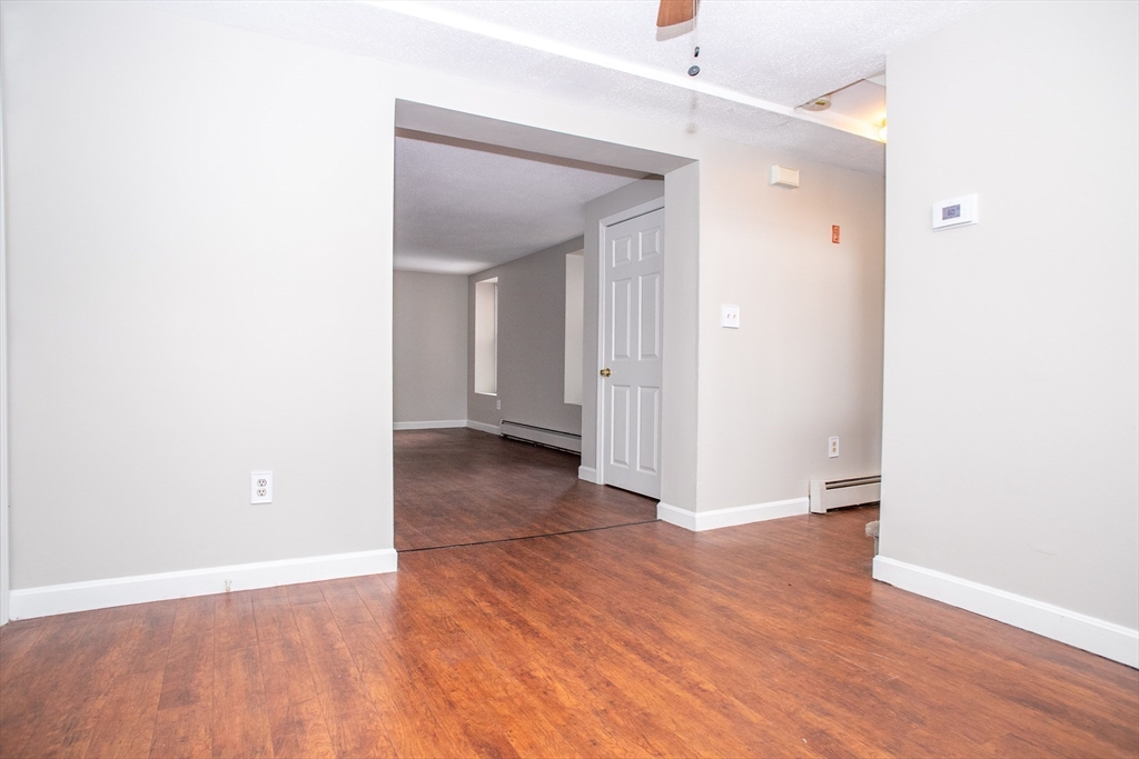 35 Cedar Street, Unit 2 Gardner, MA 01440 - Photo 11 of 32 an empty room with wooden floor and a ceiling fan