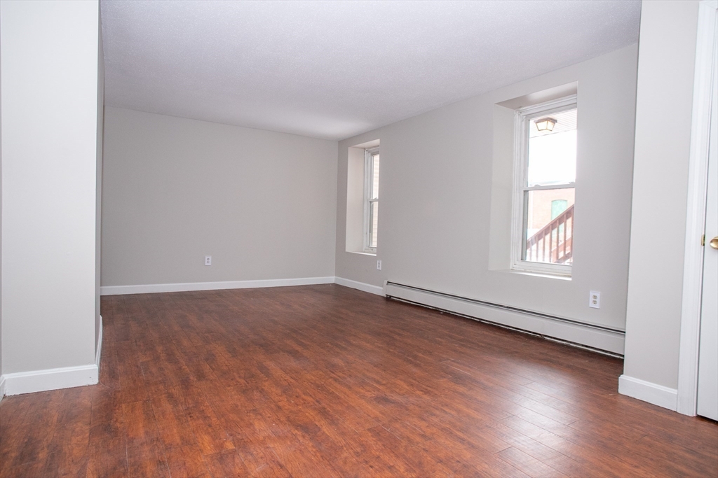 35 Cedar Street, Unit 2 Gardner, MA 01440 - Photo 12 of 32 an empty room with wooden floor and windows