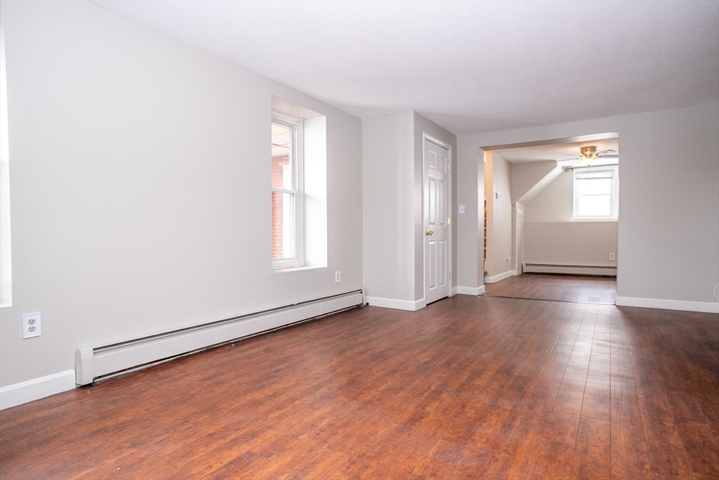 35 Cedar Street, Unit 2 Gardner, MA 01440 - Photo 15 of 32 an empty room with wooden floor and windows