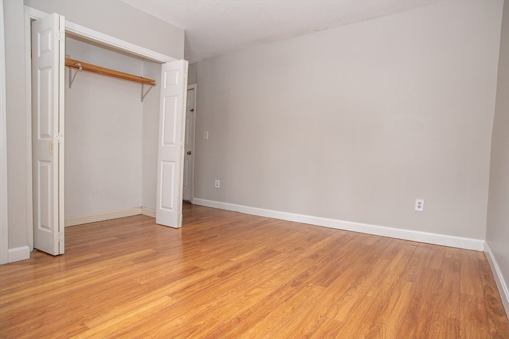 35 Cedar Street, Unit 2 Gardner, MA 01440 - Photo 21 of 32 a view of an empty room with wooden floor and a window