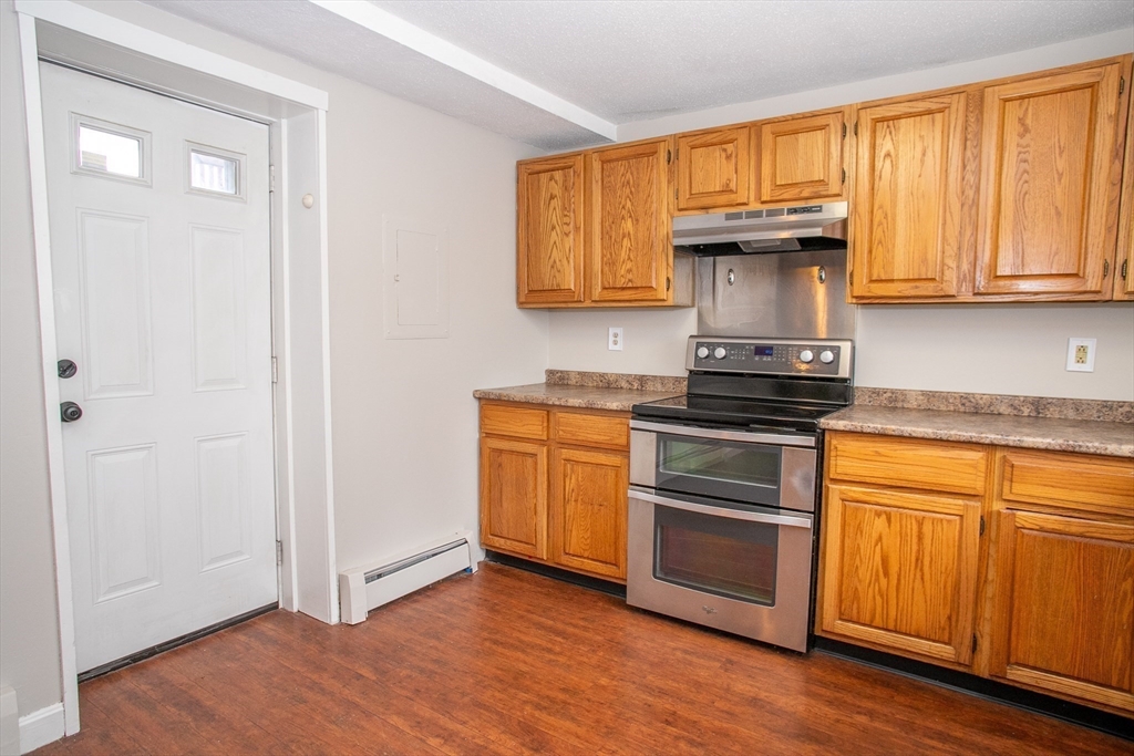 35 Cedar Street, Unit 2 Gardner, MA 01440 - Photo 5 of 32 a kitchen with granite countertop wooden floors and stainless steel appliances