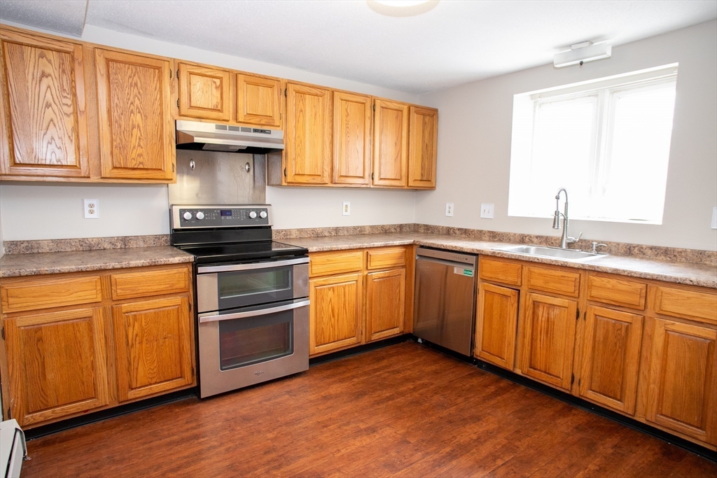 35 Cedar Street, Unit 2 Gardner, MA 01440 - Photo 6 of 32 a kitchen with granite countertop stainless steel appliances a sink cabinets and a window