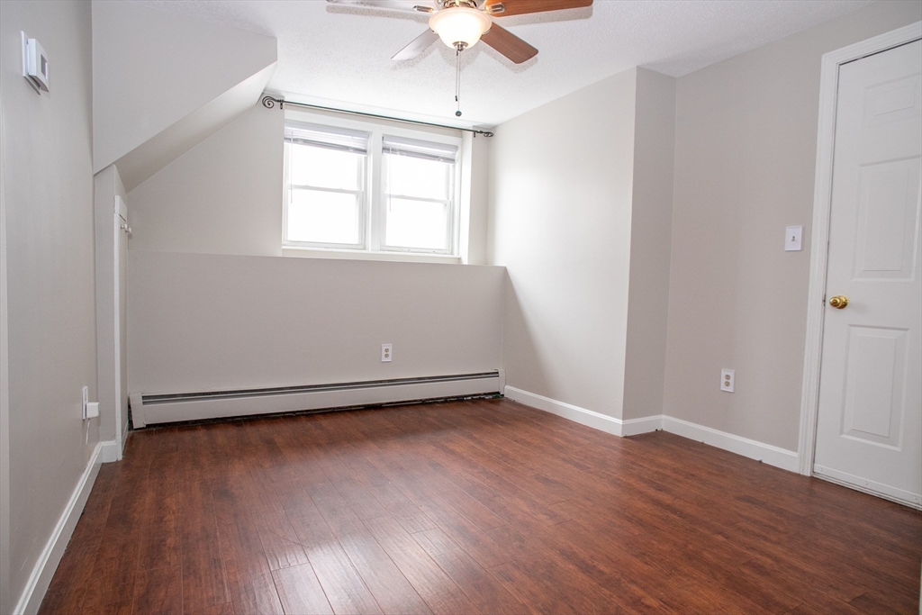 35 Cedar Street, Unit 2 Gardner, MA 01440 - Photo 10 of 32 an empty room with wooden floor chandelier fan and windows