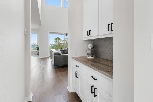 a hallway with white cabinets and potted plant