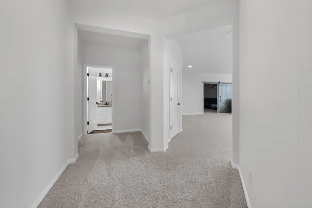 a hallway with wooden floor and cabinets