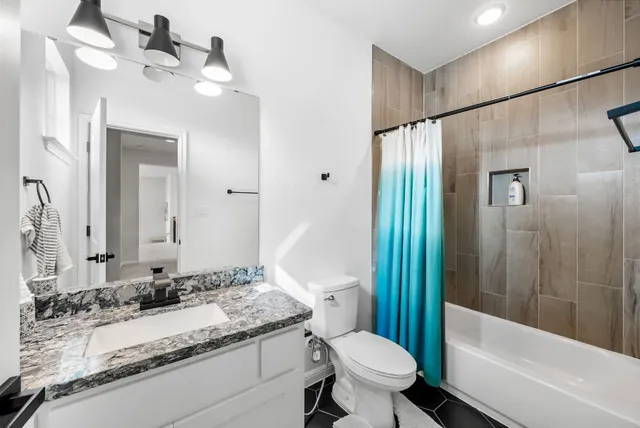 a bathroom with a granite countertop sink toilet and shower