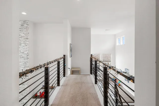 a view of a hallway with wooden floor and stairs