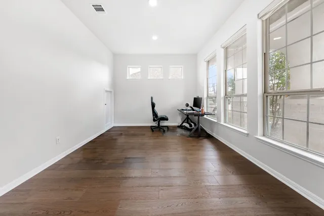 a view of a room with wooden floor and a window