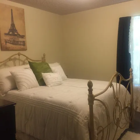 a bedroom with a bed and a flat screen tv