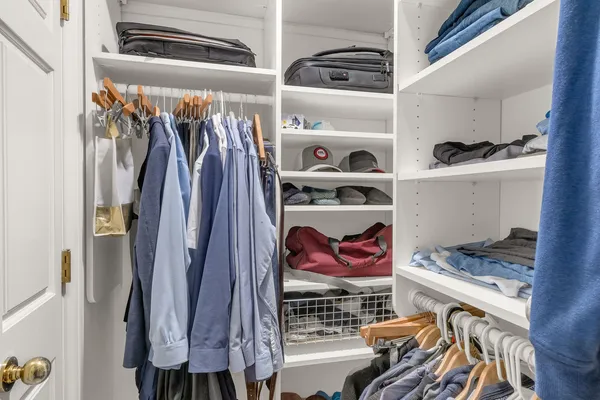 a view of walk in closet with clothes and shoes