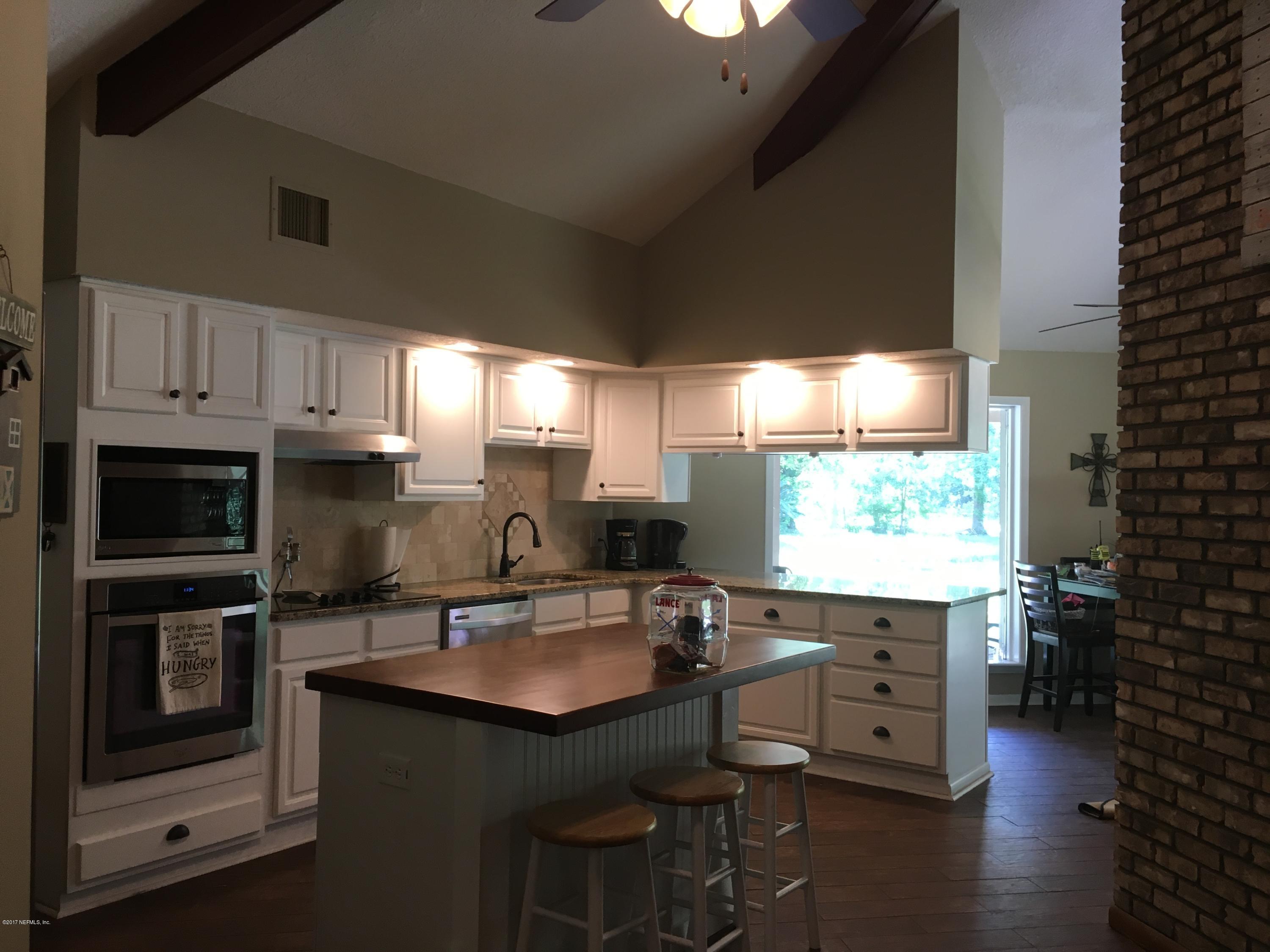 3098 Pacetti Road, Unit LOT I St. Augustine, FL 32092 - Photo 14 of 37 a kitchen with granite countertop a stove a sink and a microwave