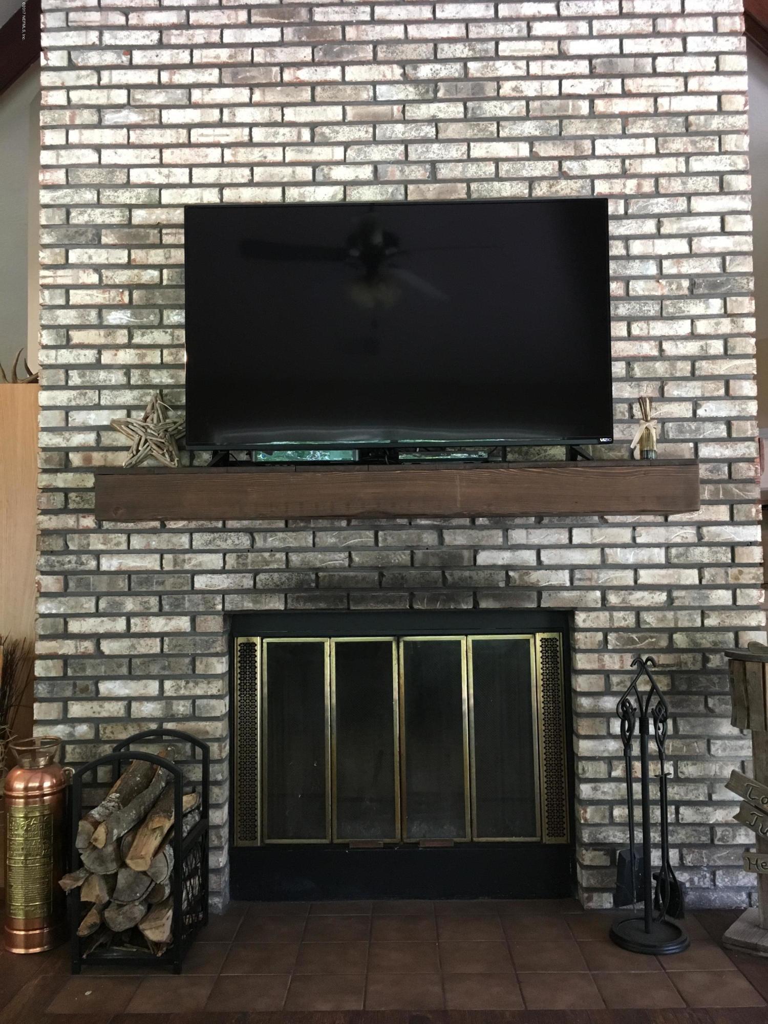 3098 Pacetti Road, Unit LOT I St. Augustine, FL 32092 - Photo 8 of 37 a living room with a fireplace and a flat screen tv
