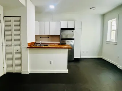 a view of kitchen with wooden floor and a window