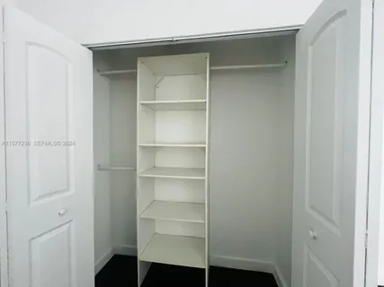 a view of walk in closet with empty racks