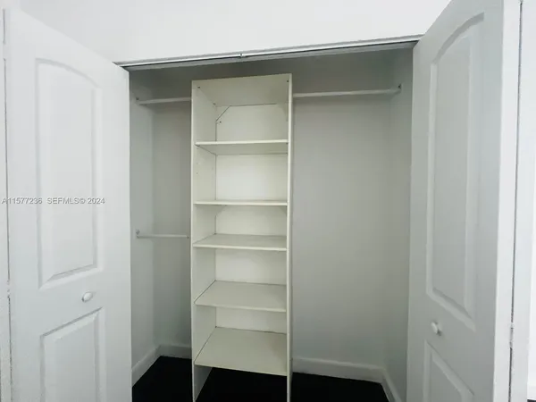 a view of walk in closet with empty racks