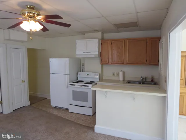 a kitchen with a stove a sink a refrigerator and cabinets