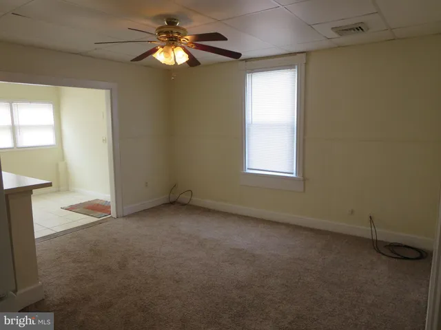 an empty room with windows and fan