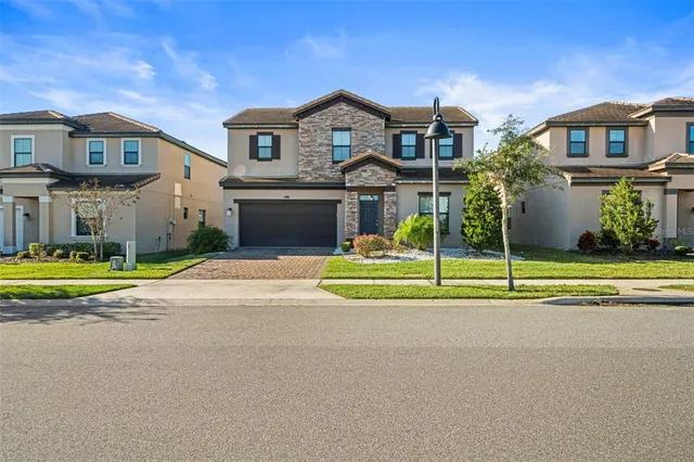 a view of a house with a big yard and large trees