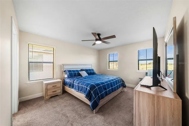 a bedroom with a bed a dresser and a chandelier