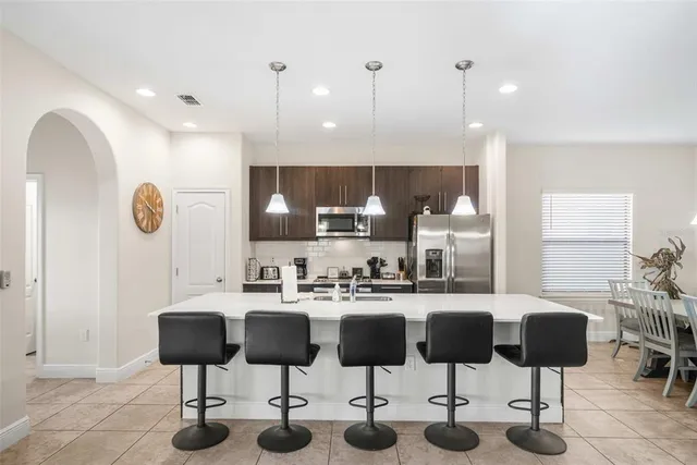 a kitchen with stainless steel appliances kitchen island granite countertop a table and chairs