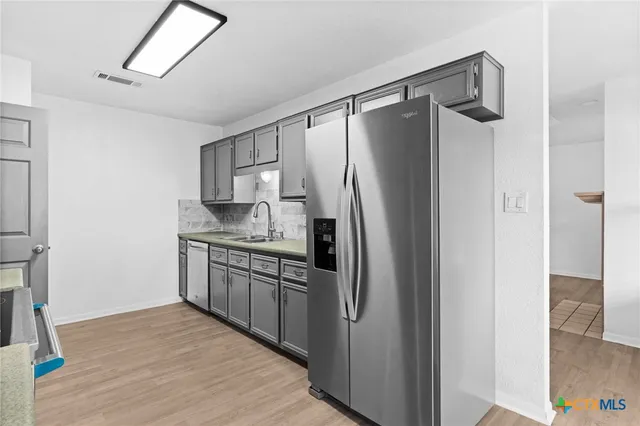 a kitchen with stainless steel appliances granite countertop a refrigerator and a sink
