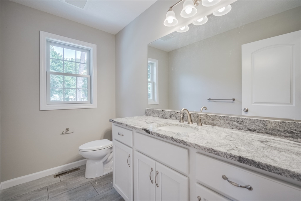10 Kittrell Street Springfield, MA 01119 - Photo 17 of 42 a bathroom with a granite countertop toilet sink and mirror