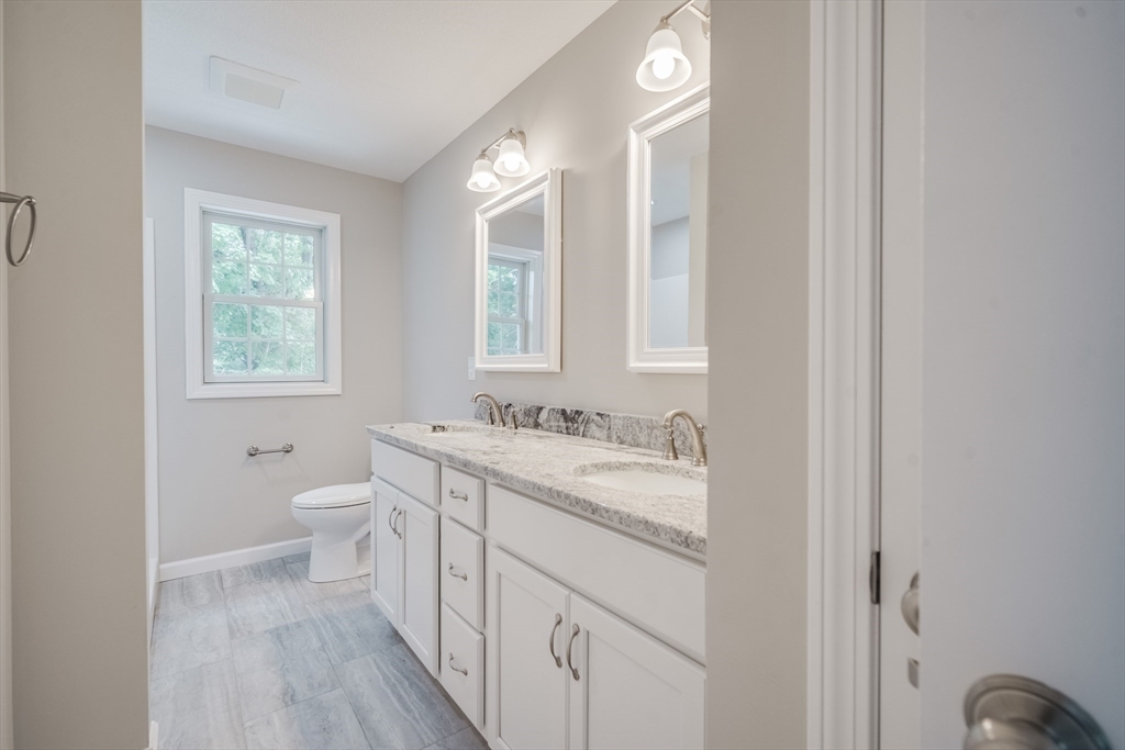 10 Kittrell Street Springfield, MA 01119 - Photo 30 of 42 a bathroom with a granite countertop toilet sink and mirror