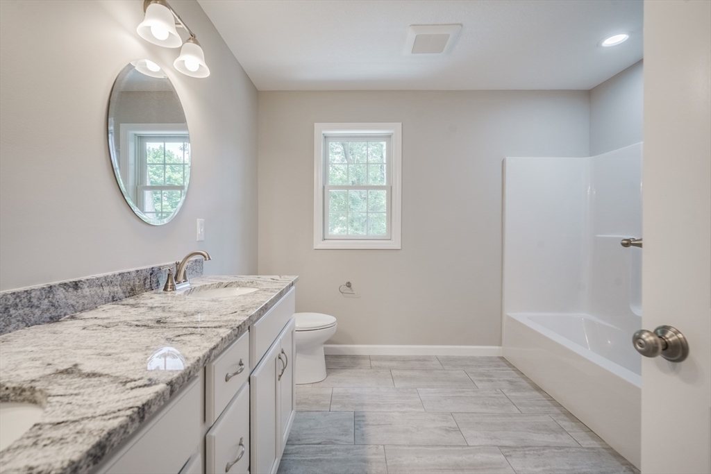 10 Kittrell Street Springfield, MA 01119 - Photo 33 of 42 a bathroom with a granite countertop sink a toilet and a mirror